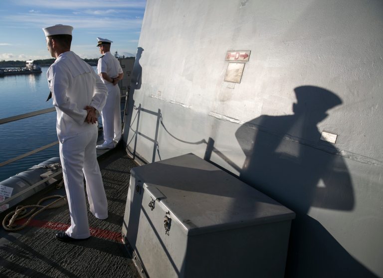 Navy sailor aboard the USS Halsey stand at parade rest as the ship passes by Kilo Pier at Pearl Harbor, Wednesday, Dec. 7, 2016, in Honolulu.