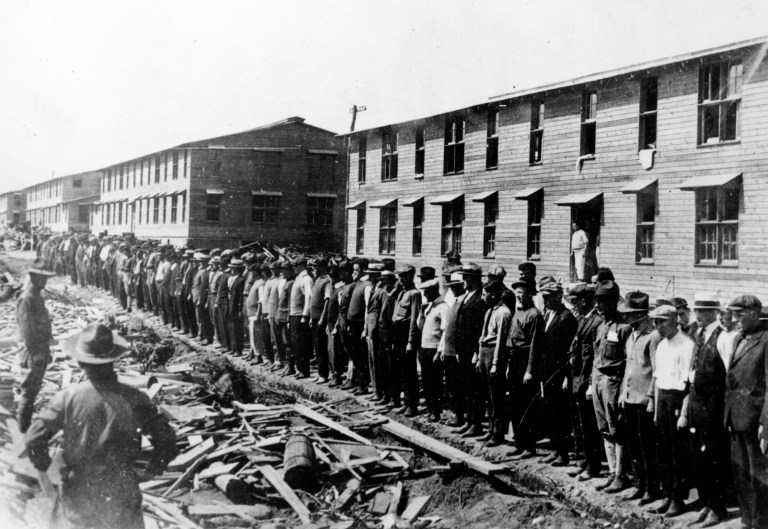 Members of the first contingent of New Yorkers drafted into the United States Army are shown lined up in front of their barracks at Camp Upton as America enters World War I in 1917.
