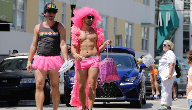 A couple walk along the parade route at the annual Miami Beach Gay Pride Parade, Sunday, April 9, 2017, in Miami Beach, Fla.