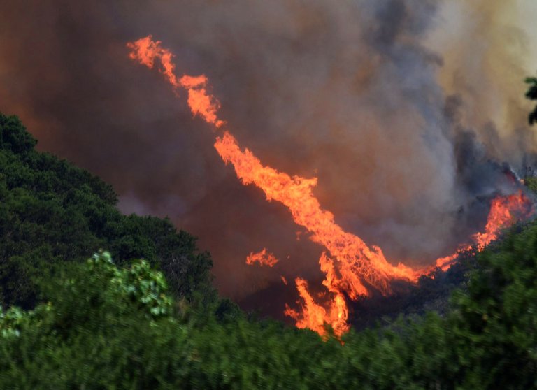 This Saturday, July 8, 2017, photo provided by the Santa Barbara County Fire Department shows a large fire whirl developing from erratic winds near Tepesquet Road in a wildfire east of Santa Maria, Calif., in Santa Barbara County, Calif. Wildfires barreled across the baking landscape of the western U.S. and Canada, destroying a smattering of homes, forcing thousands to flee and temporarily trapping children and counselors at a California campground. Southern California crews hope slightly cooler temperatures and diminishing winds will help in the battle Sunday.
