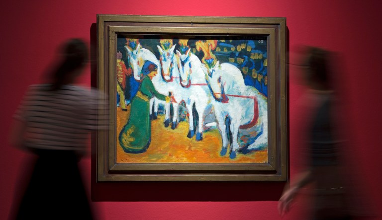 In this picture taken with a long time exposure women walk in front of the painting 'Dressage of white horses' (1908/09) by Ernst Ludwig Kirchner during the press preview exhibition 'There is only one program: Freedom!' in the art collection of the town museum in Jena, Germany, Friday, Sept. 1, 2017.