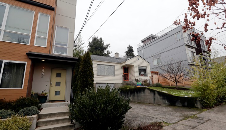 In this Dec. 27, 2017, photo, an older single-family home remains boxed-in between newer, multi-family homes in Seattle.