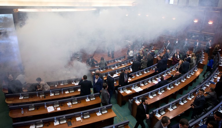 Kosovo lawmakers leave as smoke fills the auditorium of the Kosovo assembly after opposition lawmakers released tear gas canisters disrupting a parliamentary session in Kosovo capital Pristina on Wednesday.