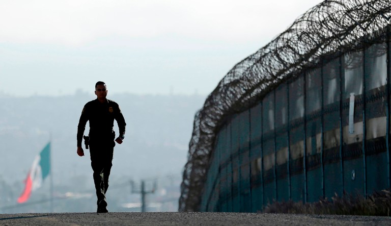Border Patrol agent walks near the secondary fence separating Tijuana, Mexico, background, and San Diego in San Diego. California Gov. Jerry Brown agreed Wednesday, April 11, 2018, to deploy 400 National Guard troops at President Trump's request. 