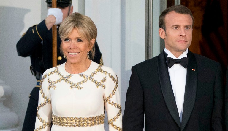 French President Emmanuel Macron and his wife Brigitte Macron pose for photographs as they arrive for a State Dinner at the White House in Washington. 