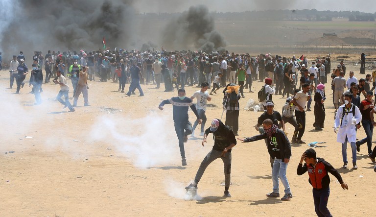 Palestinian protesters burn tires near the Israeli border fence, east of Khan Younis, in the Gaza Strip, Monday. Thousands of Palestinians are protesting near Gaza's border with Israel, as Israel prepared for the festive inauguration of a new U.S. Embassy in contested Jerusalem. 