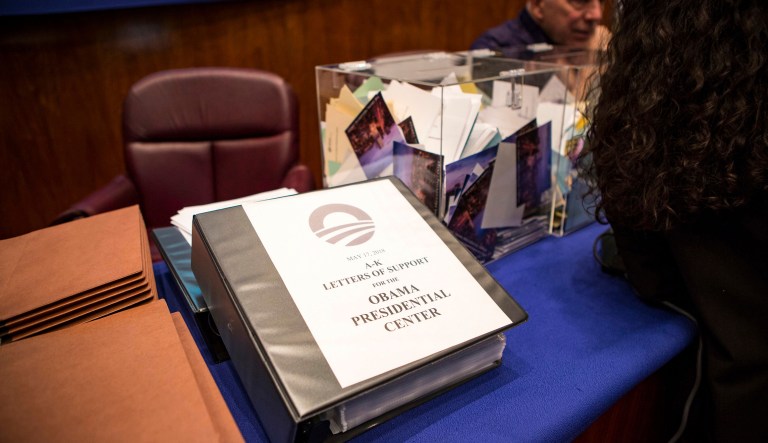 Letters of support fill a table at a planning commission meeting for the Obama Presidential Center at City Hall in Chicago. 