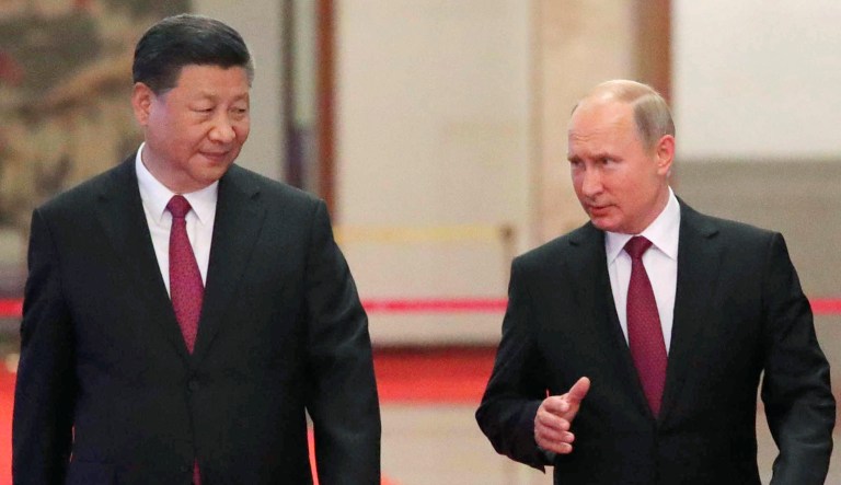 Russian President Vladimir Putin and Chinese President Xi Jinping walk during their meeting in Beijing on June 8, 2018.