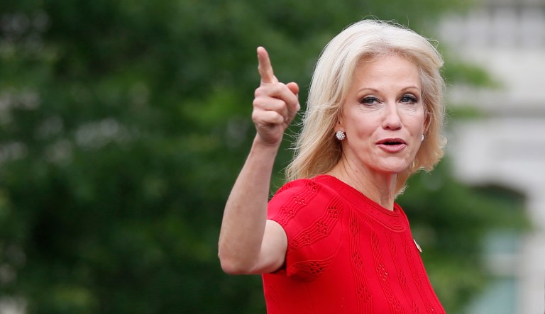 White House counselor Kellyanne Conway gestures as she walks with an aide to an interview at the White House. 