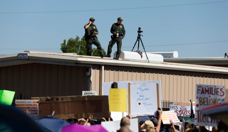 U.S. Border Patrol agents watch as they take photos and video of the crowd protesting outside the U.S. Immigration and Customs Enforcement processing center in El Paso, Texas. 