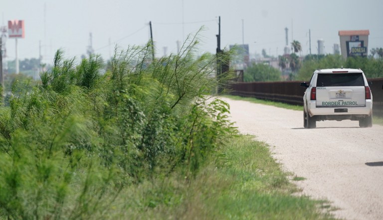 A U.S. Border Patrol vehicle drives along a fence line near the U.S.- Mexico border in Hidalgo, Texas. 