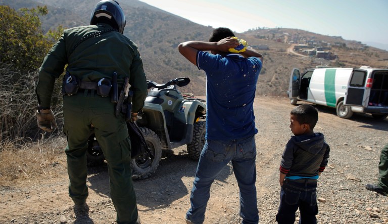 A Guatemalan father and son, who crossed the U.S.-Mexico border illegally, are apprehended by a U.S. Border Patrol agent.