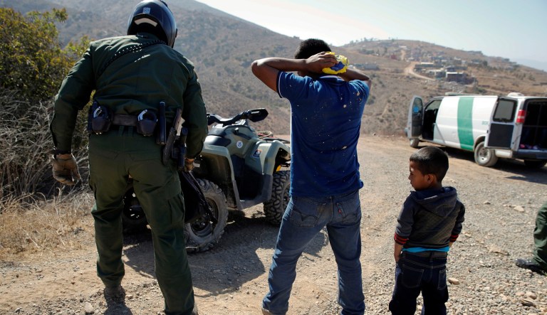 A Guatemalan father and son, who crossed the U.S.-Mexico border illegally, are apprehended by a U.S. Border Patrol agent in San Diego.  