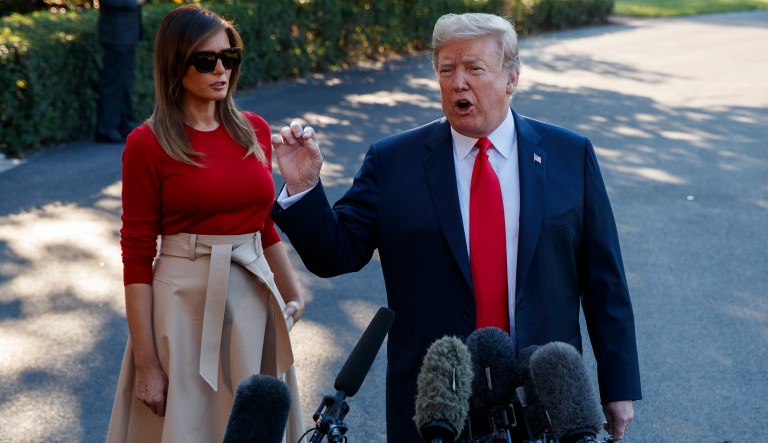First lady Melania Trump looks on as President Trump speaks with reporters before boarding Marine One on the South Lawn of the White House. 
