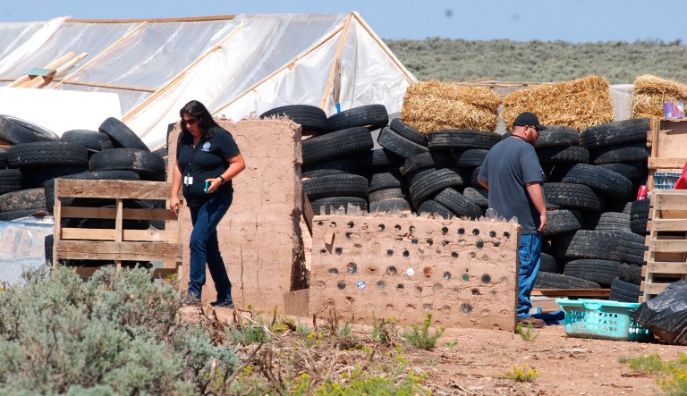 Taos County Planning Department officials survey property conditions at a disheveled living compound at Amalia, N.M. A New Mexico sheriff said searchers have found the remains of a boy at the makeshift compound that was raided in search of a missing Georgia child. 