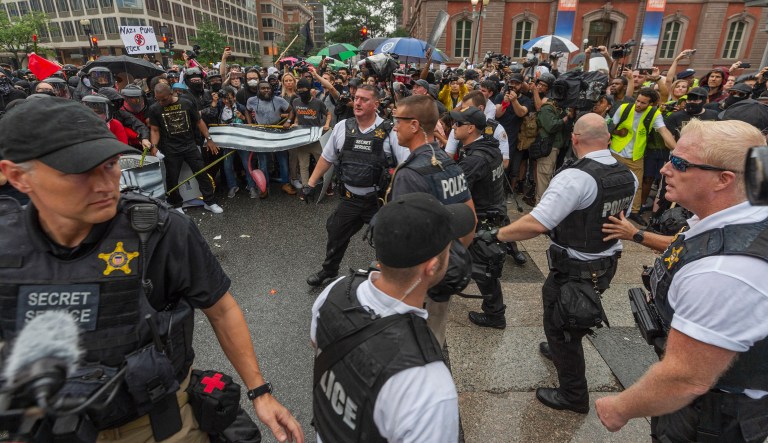 Metro Police and Secret Service personnel are forced back by counterprotesters outside of the Pennsylvania Avenue security barrier on 17th street while attempting to escort attendees of the "Unite the Right 2" rally from Lafayette Park in Washington. 