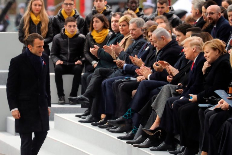 French President Emmanuel Macron walks past world leaders during a ceremony at the Arc de Triomphe, in Paris, France, as part of the commemorations marking the 100th anniversary of the 11 November 1918 armistice, ending World War I, Sunday, Nov. 11, 2018.