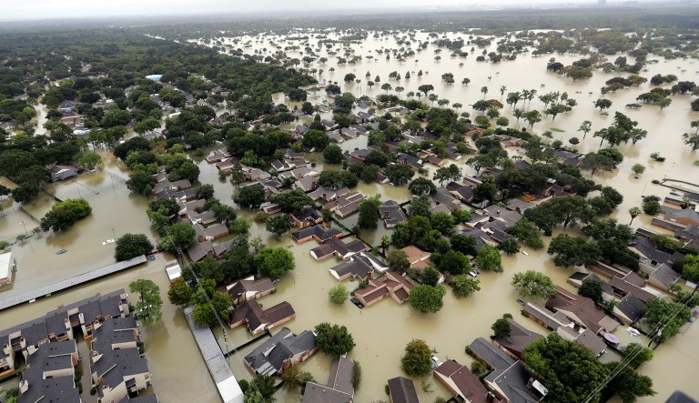 In this Aug. 29, 2017, file photo, water from Addicks Reservoir flows into neighborhoods from floodwaters brought on by Tropical Storm Harvey in Houston. Natural disasters in Texas on the scale of Hurricane Harveyâs deadly destruction last year will become more frequent because of a changing climate, warns a new report Thursday, Dec. 13, 2018, ordered by Republican Gov. Greg Abbott in a state where skepticism about climate change runs deep.