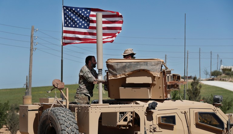 In this April 4, 2018 photo, a U.S-backed Syrian Manbij Military Council soldier, left, speaks with a U.S. soldier, at a U.S. position near the tense front line with Turkish-backed fighters, in Manbij town, north Syria. President Trump's decision to withdraw troops from Syria has rattled Washington's Kurdish allies, who are its most reliable partner in Syria and among the most effective ground forces battling the Islamic State group. Kurds in northern Syria said commanders and fighters met into the night, discussing their response to the surprise announcement Wednesday, Dec. 20, 2018.