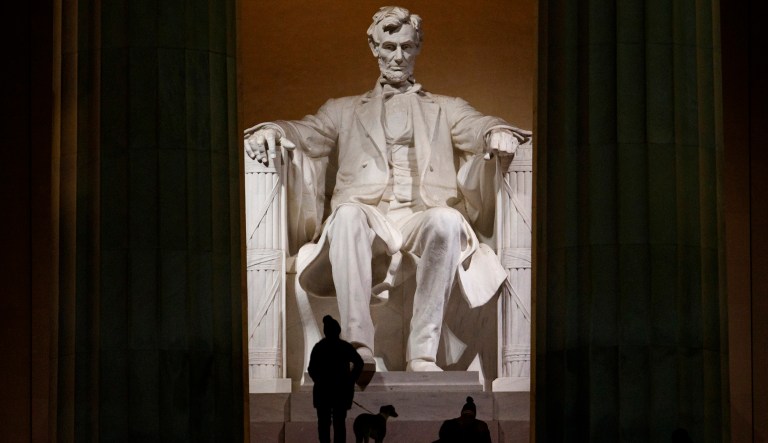 People climb the steps of the Lincoln Memorial before dawn in Washington, Saturday, Dec. 22, 2018.