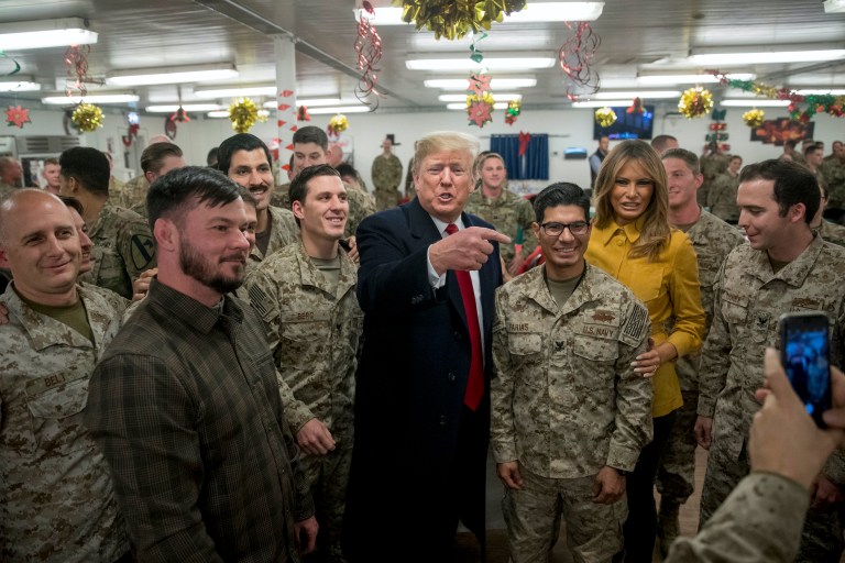 President Donald Trump and first lady Melania Trump pose for a photograph as they visit members of the military at a dining hall at Al Asad Air Base, Iraq, Wednesday, Dec. 26, 2018.
