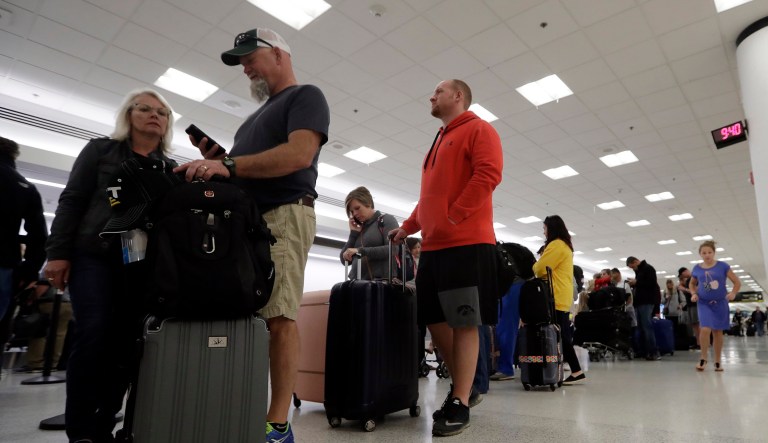 Passengers wait in line at Sun Country Airlines in Terminal G at Miami International Airport, Friday, Jan. 11, 2019, in Miami. The airport is closing Terminal G this weekend as the federal government shutdown stretches toward a fourth week because security screeners have been calling in sick at twice the airport's normal rate.