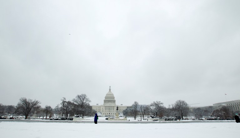 People walk outside of the U.S. Capitol building during a snowstorm, as a partial government shutdown stretches into its third week at Capitol Hill in Washington Sunday, Jan. 13, 2019. 