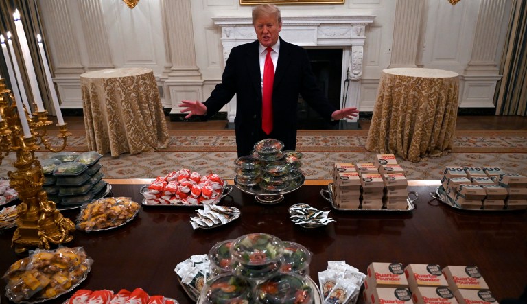 President Trump talks to the media about the table full of fast food in the State Dining Room of the White House in Washington, Monday, Jan. 14, 2019, for the reception for the Clemson Tigers.