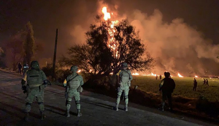 In this image provided by the Secretary of National Defense, soldiers guard the area by an oil pipeline explosion in Tlahuelilpan, Hidalgo state, Mexico, on Friday.