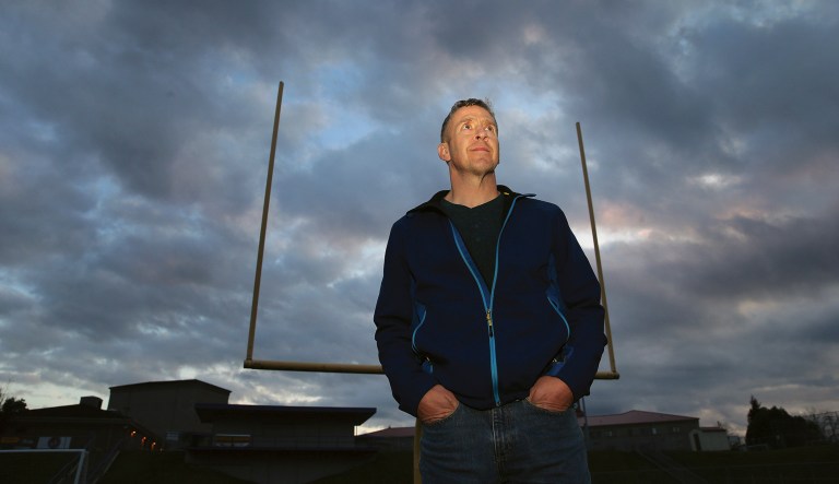 In this Nov. 5, 2015, file photo, former Bremerton High School assistant football coach Joe Kennedy poses on the field at Bremerton Memorial Stadium in Bremerton, Wash.  The Supreme Court is rejecting an appeal from a former Seattle-area football coach who lost his job because he refused to stop praying on the field. But four conservative justices say Tuesday, Jan. 22, 2019, that they are interested in former Bremerton High School Coach Joe Kennedy's case and the legal issues it raises.