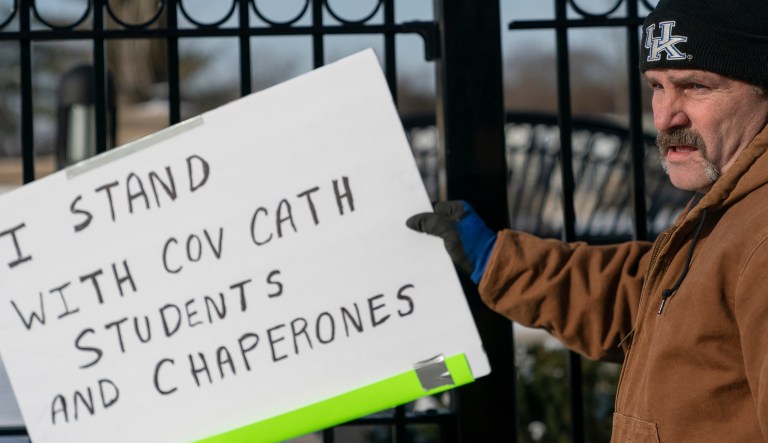 A man places a sign showing support for the students of Covington Catholic Catholic High School in front of the Catholic Diocese of Covington in Covington, Ky., Tuesday, Jan 22, 2019. 