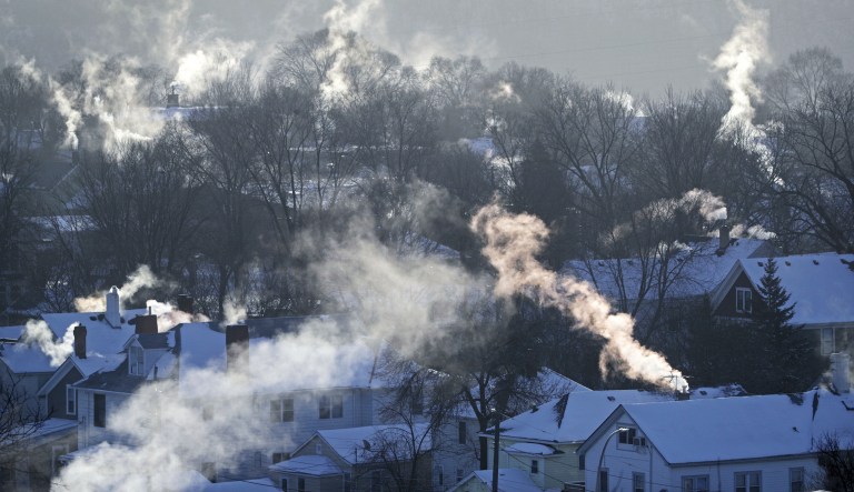 Smoke rises from the chimneys of homes in St. Paul's West 7th neighborhood Wednesday, Jan. 30, 2019, as furnaces tried to keep up with the record breaking cold, Wednesday, Jan. 30, 2019, in Minn. Xcel Energy says the extreme cold has caused some customers to lose natural gas service in central Minnesota and has the utility issuing an appeal to other customers to turn down their thermostats.