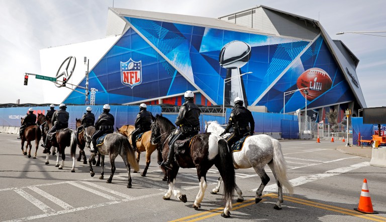 Police on horseback patrol past Mercedes-Benz Stadium ahead of Sunday's NFL Super Bowl 53 football game between the Los Angeles Rams and New England Patriots in Atlanta, Wednesday, Jan. 30, 2019.