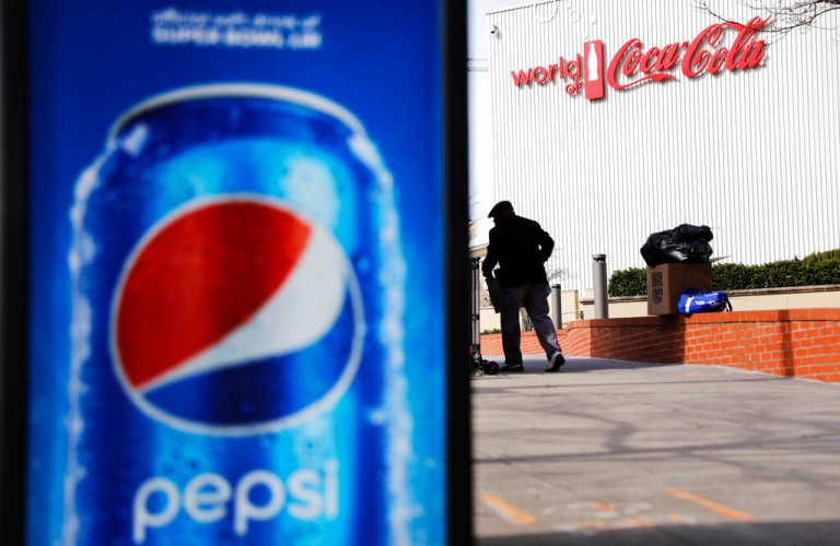 A Pepsi advertisement stands outside the World of Coca-Cola museum as a vendor stocks his kiosk in Atlanta, Wednesday, Jan. 30, 2019. The Patriots and the Rams aren't the only ones battling for Super Bowl supremacy this week. Pepsi and Coke also seem to be squaring off. Pepsi, an official NFL sponsor of Super Bowl 53, has invaded Coke's home turf, its headquarters are in Atlanta. 