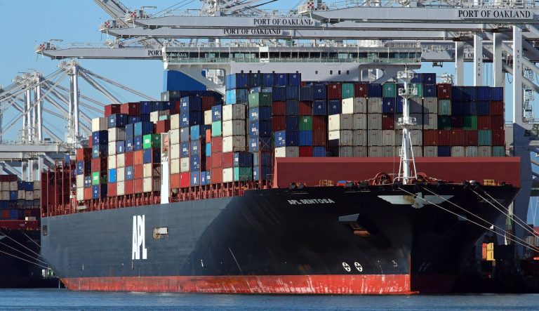 In this Dec. 6, 2018, file photo container ships docked at the Port of Oakland are unloaded on Thursday, Dec. 6, 2018, in Oakland, Calif. On Wednesday, Feb. 6, the Commerce Department reports on the U.S. trade gap for November. 