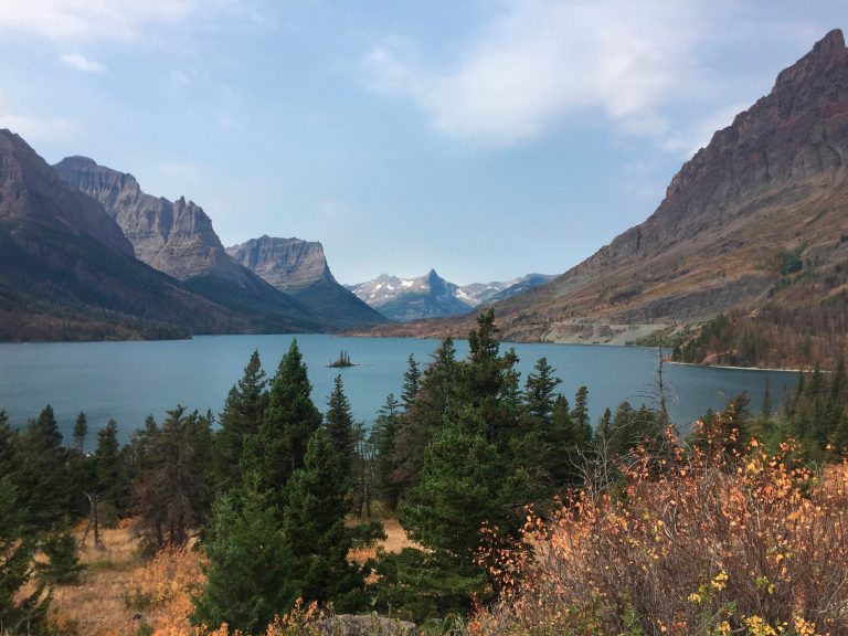 FILE - This Sept. 4, 2017 file photo shows a view from the Going-to-the-Sun Road in Glacier National Park in Montana, with a lake ringed by mountains and tall trees. (AP Photo/Beth J. Harpaz, File)