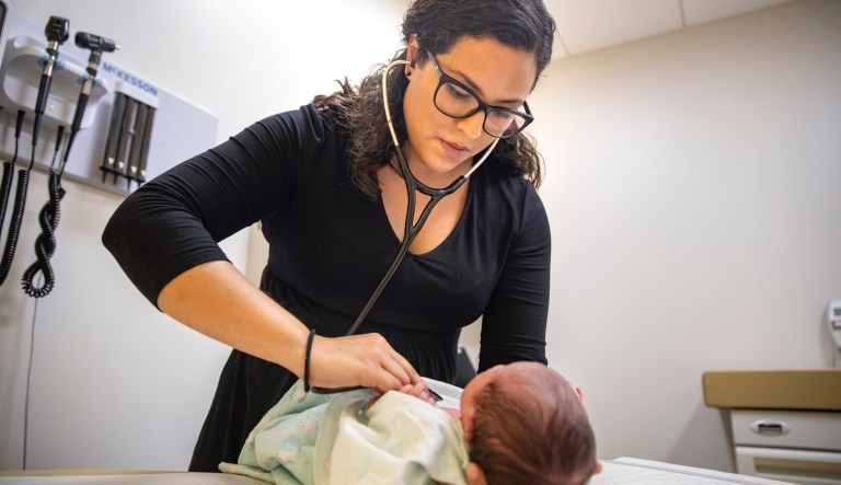 In this Tuesday, Aug. 13, 2019, photo, Dr. Jasmine Saavedra, a pediatrician at Esperanza Health Centers whose parents emigrated from Mexico in the 1980s, examines Alondra Marquez, a newborn baby in her clinic in Chicago. Doctors and public health experts warn of poor health outcomes and rising costs they say will come from sweeping changes that would deny green cards to many immigrants who use Medicaid, as well as food stamps and other forms of public assistance. Saavedra is convinced that if new Trump administration criteria were in effect for her parents three decades ago, she wouldnât have become a pediatrician.