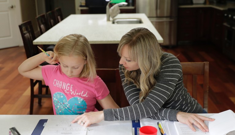 In this Oct. 9, 2019 photo, Donya Grant, right, works on a homeschool lesson with her daughter Mabry, 8, in their home in Monroe, Wash. Grantâs family is part of a group of people who have brought a lawsuit against the Monroe School District, alleging that the district had never tested for PCBs contamination at the Sky Valley Education Center school in Monroe, Wash., and had not followed a state policy to regularly inspect old light fixtures, though it had known since at least 2000 that many contained PCBs. Grant has homeschooled all of her children since they stopped attending Sky Valley in 2016 for health reasons they say were related to toxins present at the school.