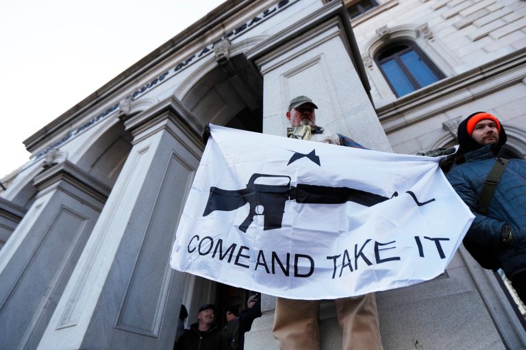 A demonstrator stands outside a court house during a pro-gun rally, Monday, Jan. 20, 2020, in Richmond, Va. Thousands of pro-gun supporters rallied to oppose gun control legislation being pushed by the newly elected Democratic legislature.