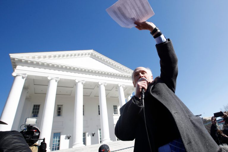 Organizer of the Pro Gun rally, Philip Van Cleave, waves to the rally as he closes it in front of the Virginia State Capitol Monday, Jan. 20, 2020, in Richmond, Va. On Monday, pro-gun advocates won their first fight, killing an assault weapon ban in a Senate committee.