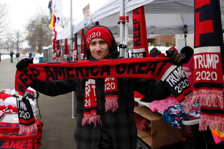 Keegan Roberts, of Phoenix, displays Trump merchandise for sale outside an evening rally for President Donald Trump, Thursday, Jan. 30, 2020, in Des Moines, Iowa.