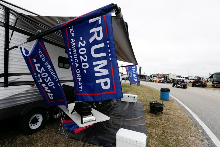 Flags supporting President Donald Trump fly in the infield before his appearance last Sunday at the NASCAR Daytona 500 auto race at Daytona International Speedway. A new survey shows him leading the 2020 election.