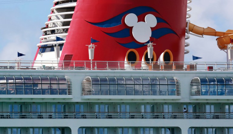 A person leans against the railing of the docked Disney Magic cruise ship at PortMiami amid the virus outbreak on Saturday, March 14, 2020, in Miami.