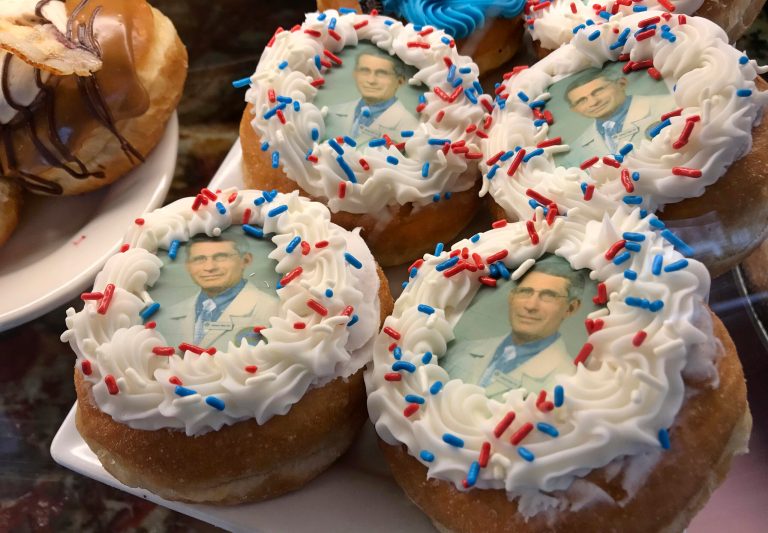 In this Wednesday, March 25, 2020 photo, donuts bearing the likeness of Dr. Anthony Fauci, director of the National Institute of Allergy and Infectious Diseases, rest on a plate at Donuts Delite in Rochester, N.Y. Donuts Delite began making donuts featuring Fauci's face earlier in the week.