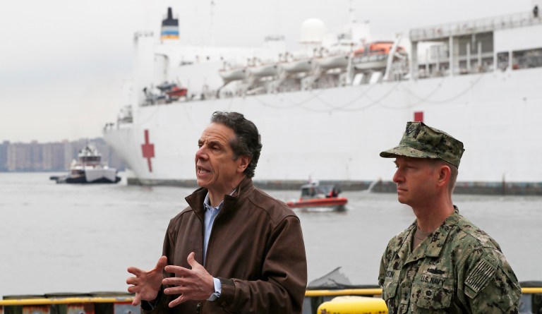 New York Gov. Andrew Cuomo, left, beside Rear Adm. John B. Mustin, welcomes the the arrival of the USNS Comfort, a naval hospital ship with a 1,000 bed-capacity, sent by President Trump to aid in the state's virus response.