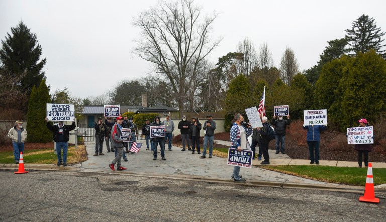 A small group of protesters gathers in front of the Governor's Mansion in Lansing, Michigan, Thursday afternoon. They were protesting Gov. Gretchen Whitmer's stay-at-home order enacted to help mitigate the spread of the COVID-19 coronavirus.