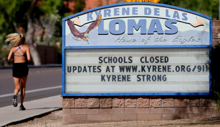 A runner passes a school closed sign Friday, April 24, 2020, in Phoenix. It took a decade for Arizona lawmakers to restore much of the school funding they cut in the wake of the Great Recession. Now, education leaders fear a looming recession created by the coronavirus could once again mean reductions in school funding. (AP Photo/Matt York)