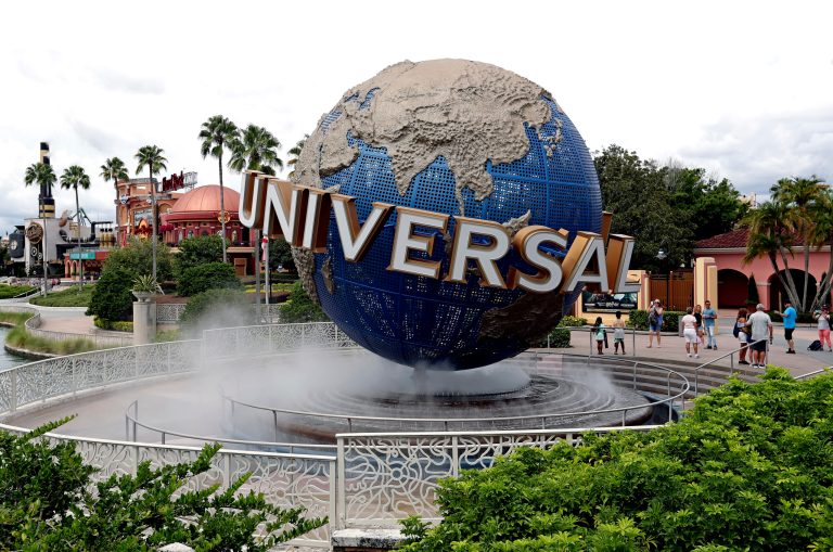 FILE - In this Aug. 5, 2019 file photo, guests cool off under a water mist by the globe at Universal Studios City Walk at Universal Studios Florida in Orlando, Florida. (AP Photo/John Raoux, file)