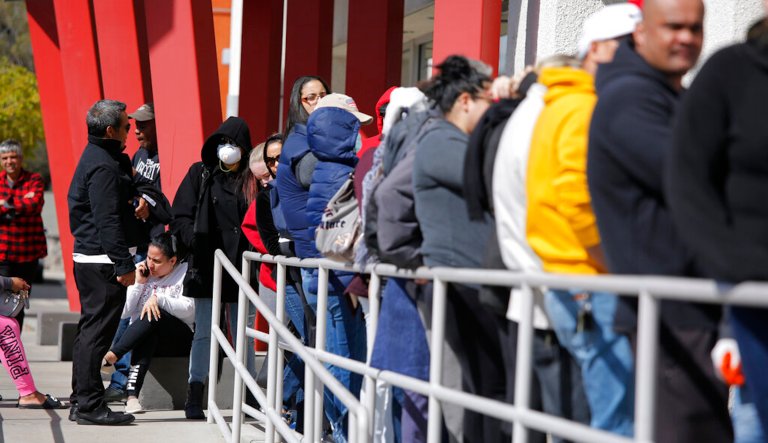 In this March 17, 2020, file photo, people wait in line for help with unemployment benefits at the One-Stop Career Center in Las Vegas. A Nevada judge says the state unemployment benefits office has to begin paying pandemic relief benefits to out-of-work gig and independent workers who havenât completely stopped working and were cut off from receiving payments.                                                                                                                                                                              