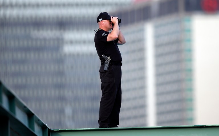 A member of the Boston police SWAT squad stands on the roof of Fenway Park before an opening day baseball game between the Boston Red Sox and the Baltimore Orioles, Friday, July 24, 2020, in Boston.
